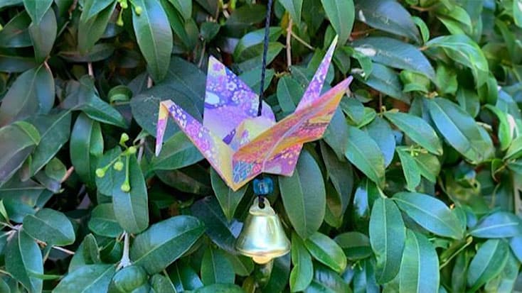 An origami crane hanging from a bush as a symbolic act of Cupertino Sister Cities' Bell Ringing for World Peace.
