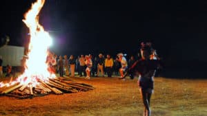 A group of people standing around a bonfire.
