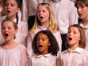 A group of children singing with their mouths open.