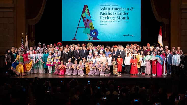 A diverse group of people in colorful traditional attire on stage at the 2024 APA Heritage Awards in San Francisco, celebrating Asian American and Pacific Islander Heritage Month.