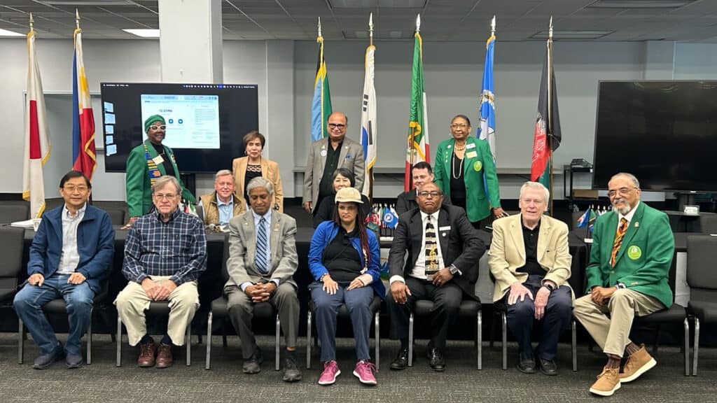 Fourteen people pose for a group photo in front of a row of international flags following the Northern California Chapter of Sister Cities International's quarterly board meeting held May 17 2025 in Vallejo, CA