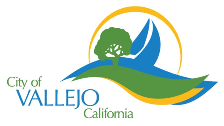 City of Vallejo, California logo featuring a tree, stylized hills, water, and a yellow sun in the background; often seen at Vallejo Sister City Commission or Vallejo meeting events.